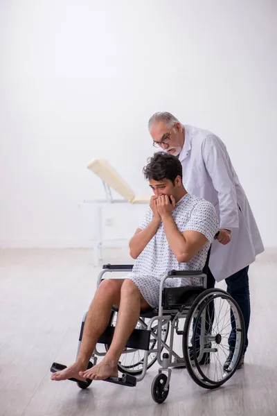 Old male doctor psychiatrist examining young disabled patient