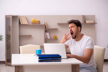 Genç erkek çalışan salgın sırasında evden çalışıyor.