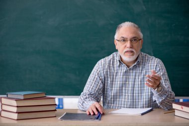 Sınıftaki yaşlı erkek öğretmen.
