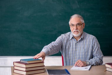 Sınıftaki yaşlı erkek öğretmen.