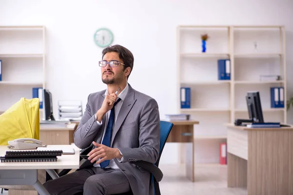 Joven empleado masculino que cuida a recién nacido en el lugar de trabajo — Foto de Stock