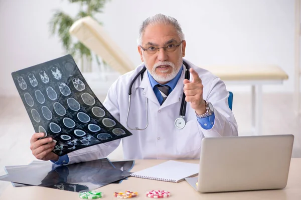 Gammal manlig röntgenläkare som arbetar på kliniken — Stockfoto