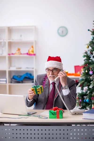 Alderen mandlige medarbejder fejrer jul på arbejdspladsen - Stock-foto