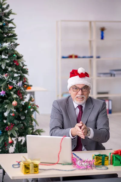 Funcionário idoso do sexo masculino comemorando o Natal no local de trabalho — Fotografia de Stock