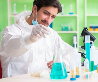 Laboratuvarda yeni bir deney üzerinde çalışan kimyager.