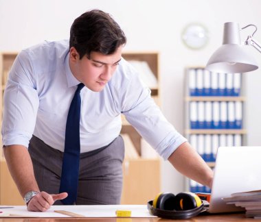 Ofiste çizimler üzerinde çalışan bir mühendis.