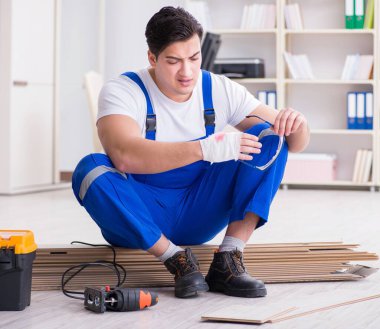 Zemin kaplamalarında çalışan genç bir işçi.