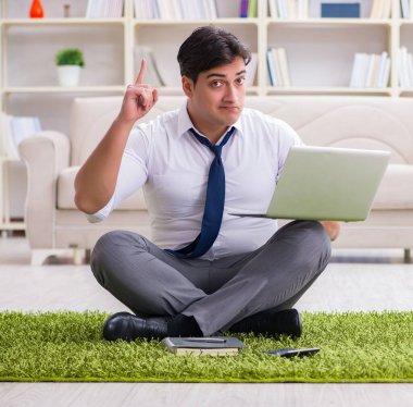 İş adamı ofiste yerde oturuyor.