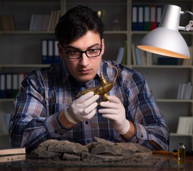 Arkeolog geç saatlere kadar ofiste çalışıyor.