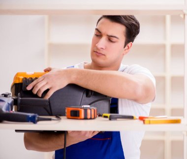 İşçi adam montaj kitaplığını tamir ediyor