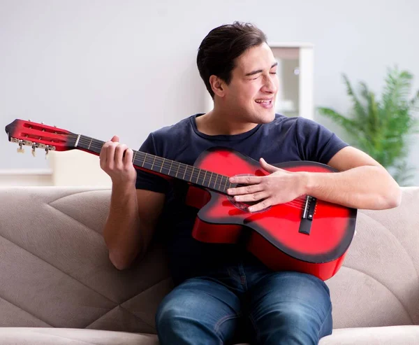 Young man practicing playing guitar at home — Stock Photo, Image