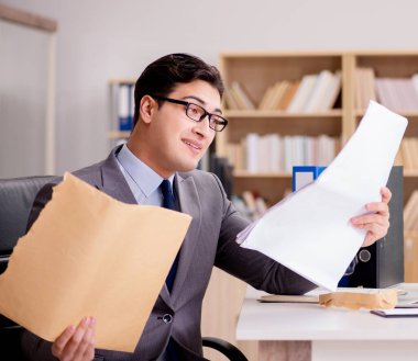 İşadamı mektup zarfını ofisinde alıyor.