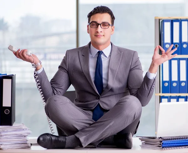 Бизнесмен медитирует в офисе — стоковое фото