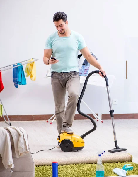 집에서 진공청소기로 청소하는 젊은 남편 — 스톡 사진