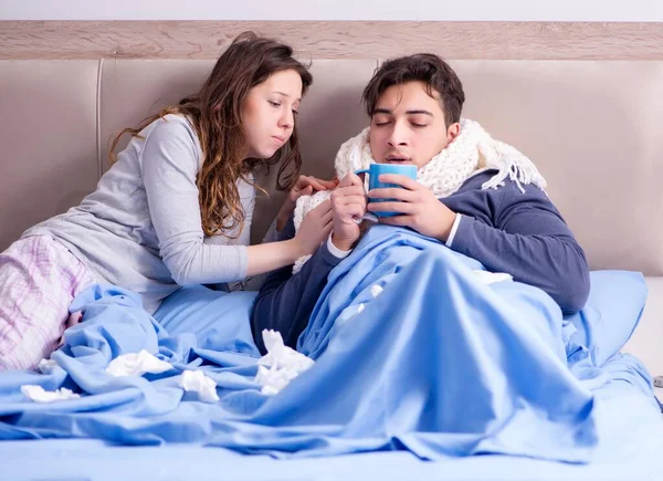 Vrouw die zorgt voor zieke man thuis in bed — Stockfoto