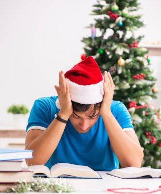 Noel arifesinde kitabı olan genç bir öğrenci.