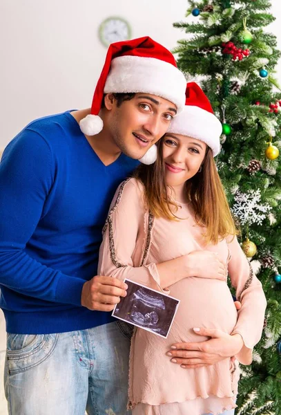 Gravid fru celevrating jul med make — Stockfoto