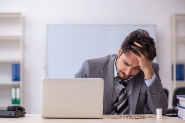 İş yerinde acı çeken genç bir işadamı