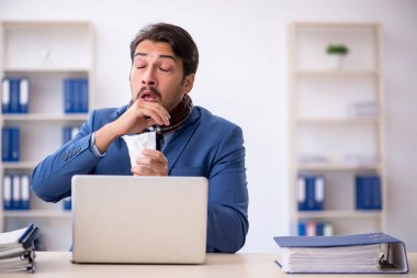 İş yerinde acı çeken genç bir erkek işçi.