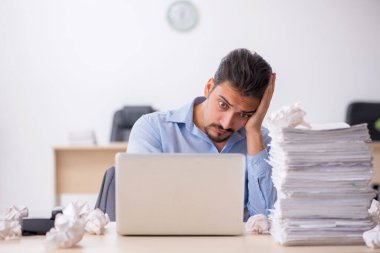 Genç bir erkek çalışan ofiste yeni fikirleri reddediyor.