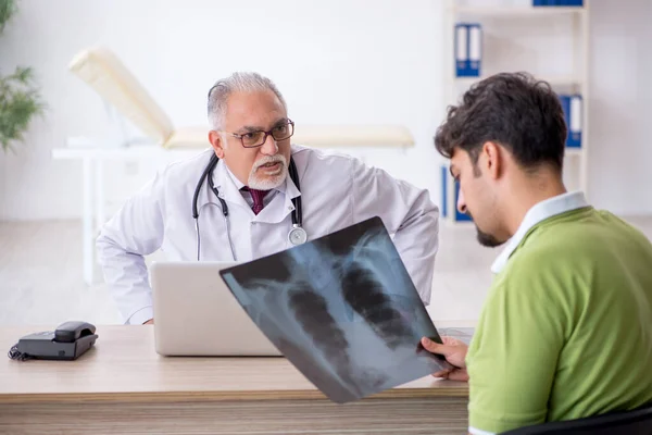 Jonge mannelijke patiënt op bezoek bij oude mannelijke arts radioloog — Stockfoto