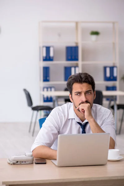 Young male employee unhappy with excessive work in the office — Stock Photo, Image