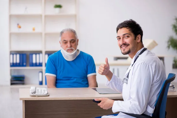 Alter Hals verletzt männliche Patientin besucht junge männliche Ärztin — Stockfoto