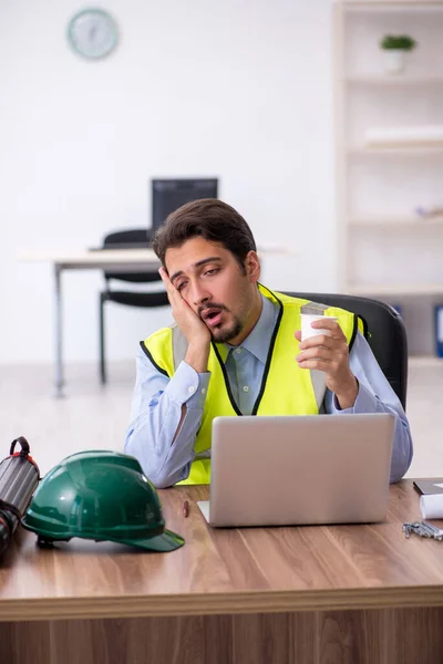 Müder junger männlicher Architekt trinkt in der Pause Kaffee — Stockfoto