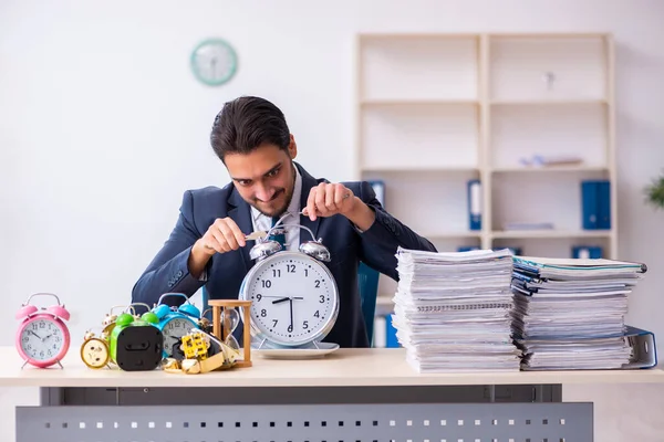 Jovem empresário empregado comer despertador-relógio — Fotografia de Stock