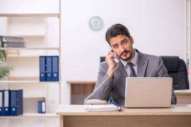 Ofiste çalışan genç bir erkek.