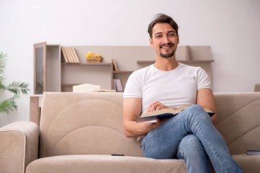 Genç erkek öğrenci salgın sırasında evde çalışıyor.