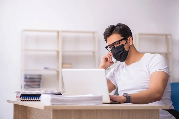 Jovem estudante do sexo masculino que trabalha no local de trabalho durante a pandemia — Fotografia de Stock