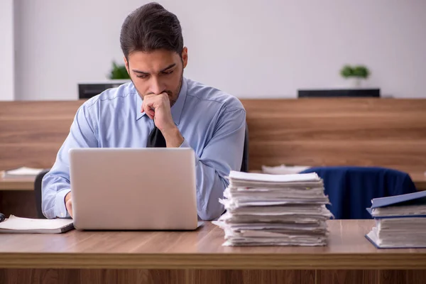 Jeune employé masculin et trop de travail au bureau — Photo