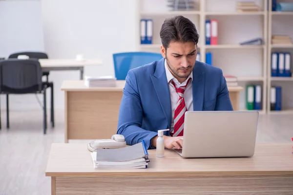 Jeune travailleur masculin souffrant sur le lieu de travail — Photo