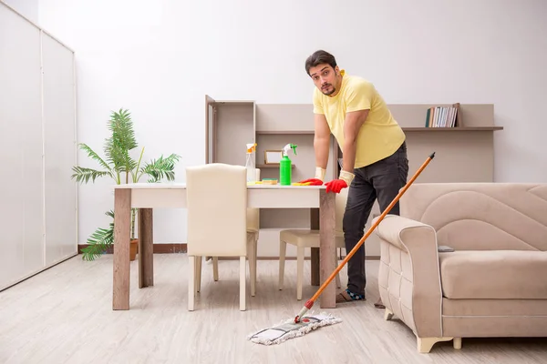 Jonge mannelijke aannemer schoonmaken van het huis — Stockfoto