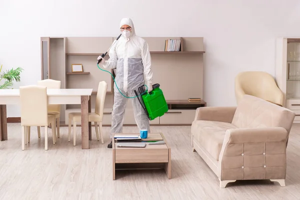 Jovem empreiteiro fazendo controle de pragas em casa — Fotografia de Stock