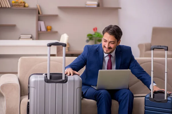 Young businessman preparing for trip at home — Stock Photo, Image