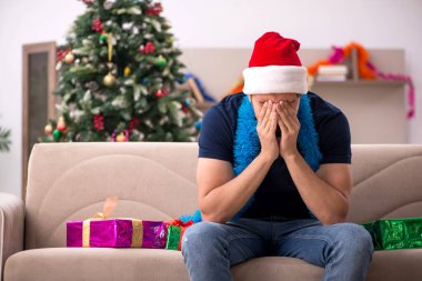 Genç adam Noel 'i evde kutluyor.