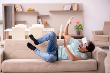 Evde sanal gözlük takan genç bir öğrenci.