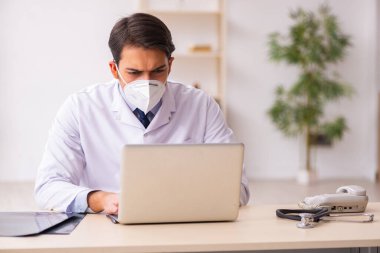 Salgın sırasında teletıp konseptinde genç bir erkek doktor.