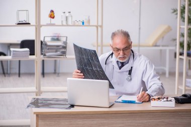 Klinikte çalışan yaşlı bir erkek radyolog.