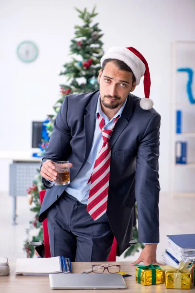 Молодий чоловік працівник святкує Різдво на робочому місці — стокове фото