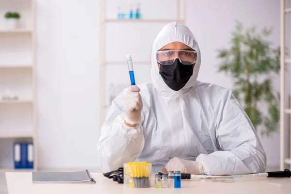 Jeune chimiste masculin travaillant au laboratoire pendant la pandémie — Photo