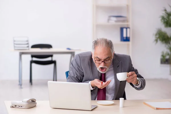 Vecchio uomo d'affari sentirsi male sul posto di lavoro — Foto Stock