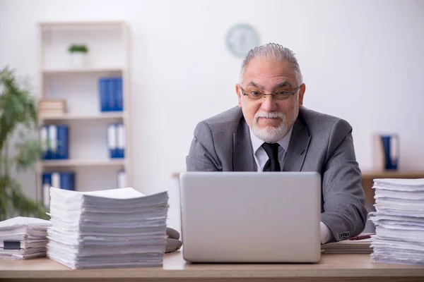 Vecchio dipendente maschio infelice con il lavoro eccessivo in ufficio — Foto Stock