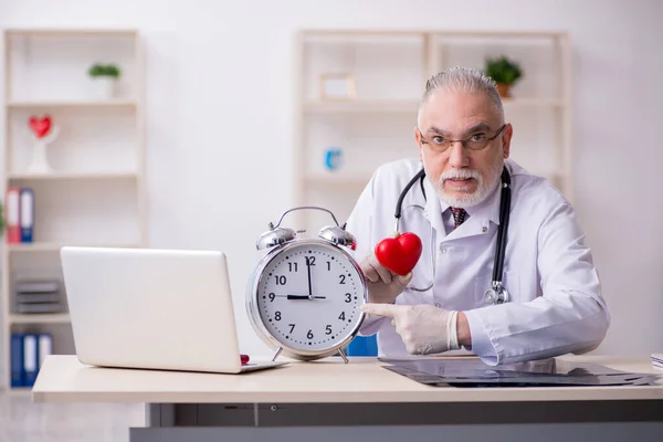 Viejo médico masculino en concepto de gestión del tiempo — Foto de Stock