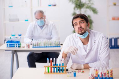 Laboratuvarda uyuşturucu sentezi konseptinde iki erkek kimyager.