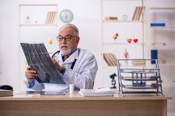 Klinikte çalışan yaşlı bir erkek radyolog. — Stok fotoğraf