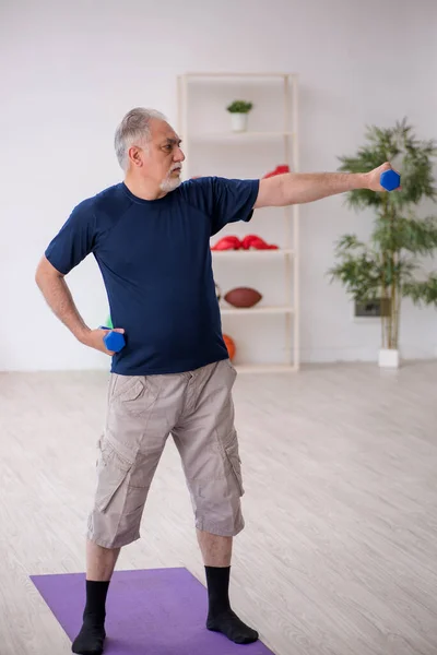 Viejo haciendo ejercicios deportivos en el interior — Foto de Stock
