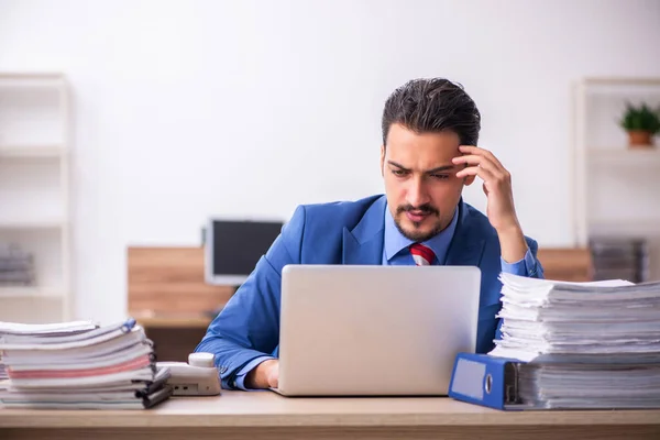 Jovem trabalhador masculino infeliz com excesso de trabalho no local de trabalho — Fotografia de Stock